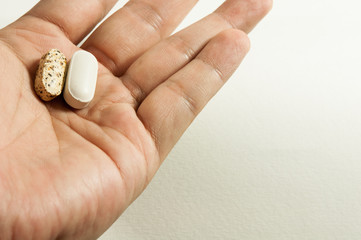 medicine, vitamin color white and brown in hand on white background