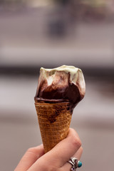 Hand holding a melting ice cream cone