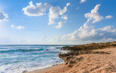 Fototapeta na wymiar Mediterranean sea with waves and shell beach at sunny summer day. 