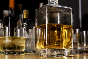 Fototapeta na wymiar Square glass bottle of scotch on the wooden bar