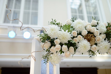 Beautiful wedding arch for marriage decorated with lace fabric and flowers. White decor for bride and groom. Colorful decoration for celebration. Beauty bridal interior