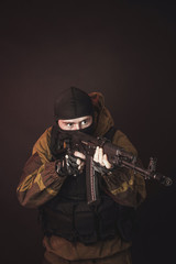 Fototapeta na wymiar The man in the image of a member of the special forces division with assault rifle in blue light. Russian police special force - Special Rapid Response Unit or SOBR (Spetsnaz).