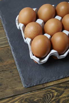 Chicken eggs on a rustic wooden background forming a page border