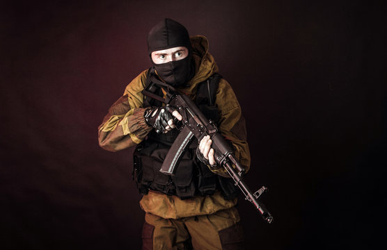 The man in the image of a member of the special forces division with assault rifle in blue light. Russian police special force - Special Rapid Response Unit or SOBR (Spetsnaz).
