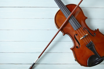 A violin and bow on a blue painted wooden background