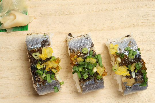Grilled pacific saury sushi with green onion and citrus fruits