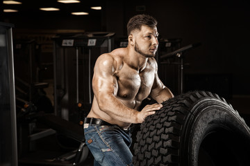 Fototapeta na wymiar Strong Athletic Man bodybuilderl Torso showing muscles in gym