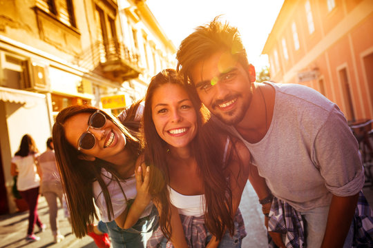 Group of happy young friends having fun on city street.Sunset.Close up image.