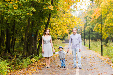 Young family walking in the park an autumn day