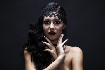 Portrait of a gorgeous brunette with a hat over black background