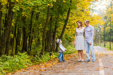 Young family walking in the park an autumn day