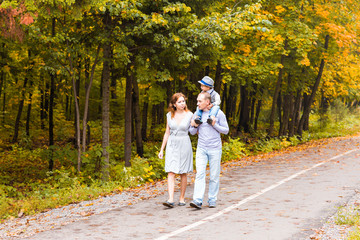 Fototapeta premium Young family walking in the park an autumn day