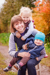 mother with son and daughter smiling outdoors