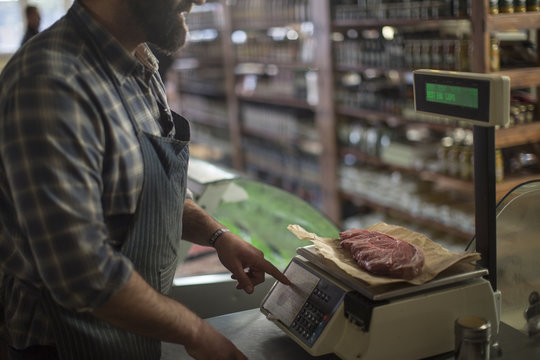 Butcher weighing meat on scale