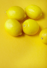 Lemons arranged on a colorful yellow background forming a page border