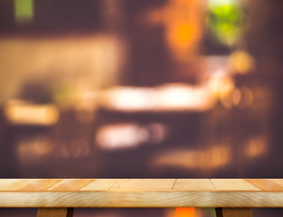 Empty wooden table and blurred restaurant bokeh light background