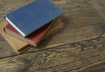 A stack of hard back journals on an old wooden desk top background