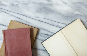 A pile of old story books on a white marble desk top background