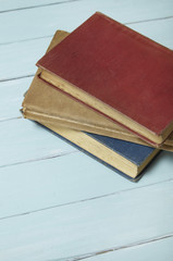 A pile of old library books on a blue wooden desk top background