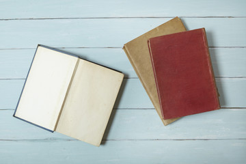 A pile of old story books on a blue wooden desk top background