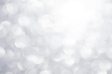 Silver white glittering Christmas lights. Festive abstract glitter bokeh background