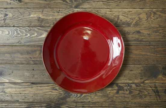 An Empty Red Plate On A Rustic Wooden Table Top Background