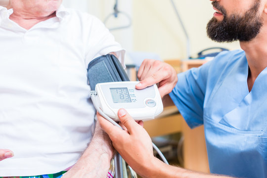 Krankenpfleger misst Blutdruck eines Patienten