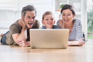 At home, cheerful family sharing a funny video on a laptop