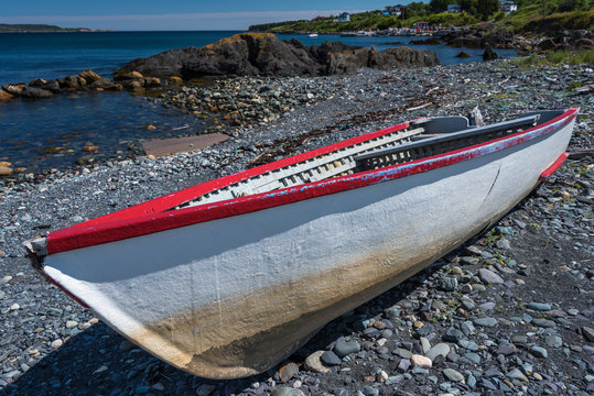 small wooden boat beached on shore