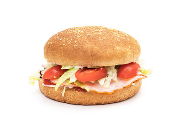 Wholemeal hamburger bun with ham, salad, tomatoes and mayonnaise on white background 