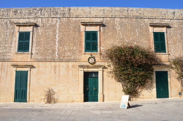 Old house in Malta with green windows