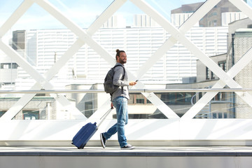 Man walking with suitcase and cellphone