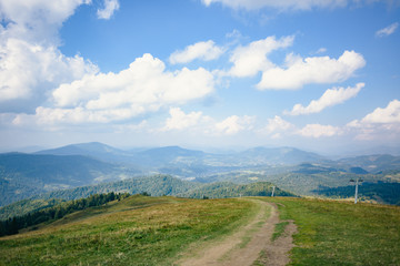 Walkway on top of the hill in Carpathian mountains. Beautiful blue sky with clouds in the background. Summer time.