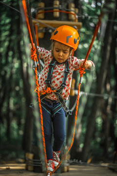 sports happy kid climbs through the ropes