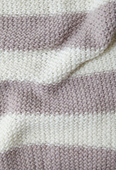A full page of dusky pink and white stripe knitted sweater background texture