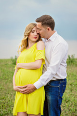 Portrait beautiful young couple waiting for baby. Photo shoot at nature
