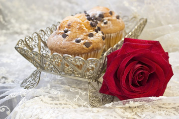 Obraz na płótnie Canvas two muffins with chocolate and beautiful red rose