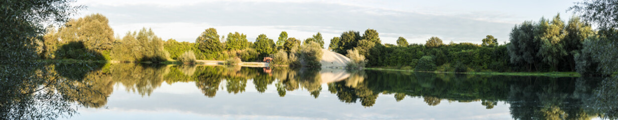 Fototapeta na wymiar Spiegelung an einem See im Unterallgäu - Panorama