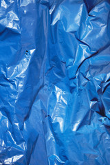 A full page of bright blue plastic refuse sack material background texture