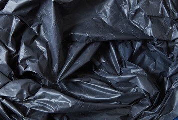 A full page of black plastic garbage sack material background texture