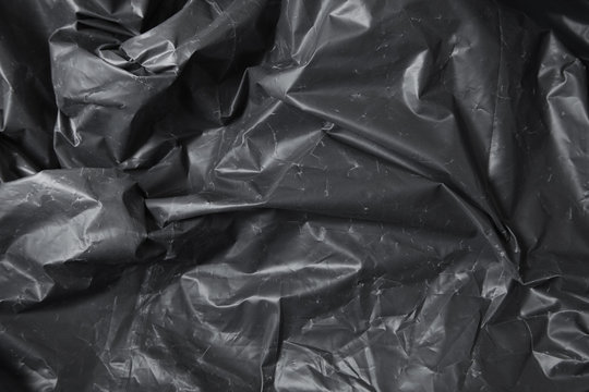 A full page of black plastic refuse sack material background texture