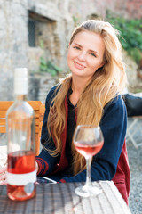 Woman enjoying wine in outdoor restaurant. Portrait of a beautiful wine tasting tourist girl.
