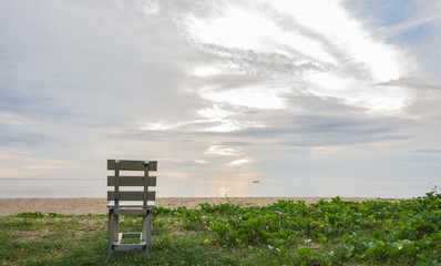 old wooden white chair on beach at sunrise time