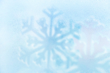 Blue ice cold water drop with snowflake background. Winter holiday.