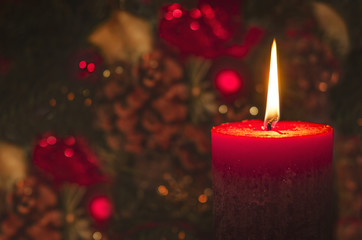 Rote Kerze mit weihnachtlichem Hintergrund