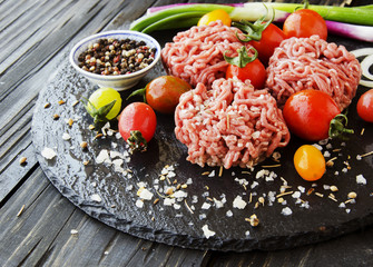 raw minced meat, vegetables with salt and spices, selective focus