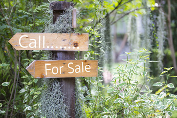 Call for sale word on Old wooden signs in the garden.
