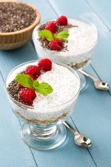 Chia yogurt with raspberries on blue wooden background

