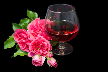 Composition with pink wine in glases and pink roses isolated on black