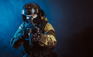 The man in the image of a member of the special forces division with assault rifle in blue light. Russian police special force - Special Rapid Response Unit or SOBR (Spetsnaz).